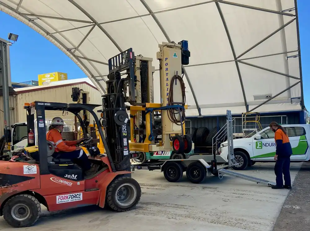 Unloading the heavy vehicle portable hoists from the truck ready for servicing trucks and vehicles.